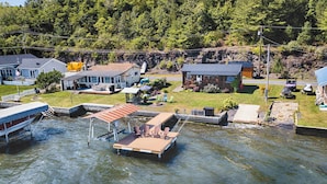 Une propriété au bord du lac, dotée d’un quai, d’un espace salon extérieur et d’un petit chalet.