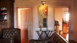 Una sala de estar acogedora con un sofá de cuero, un mueble de madera y un cuadro en la pared.