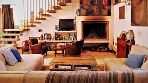 Una sala de estar acogedora con chimenea, muebles de madera y televisor.