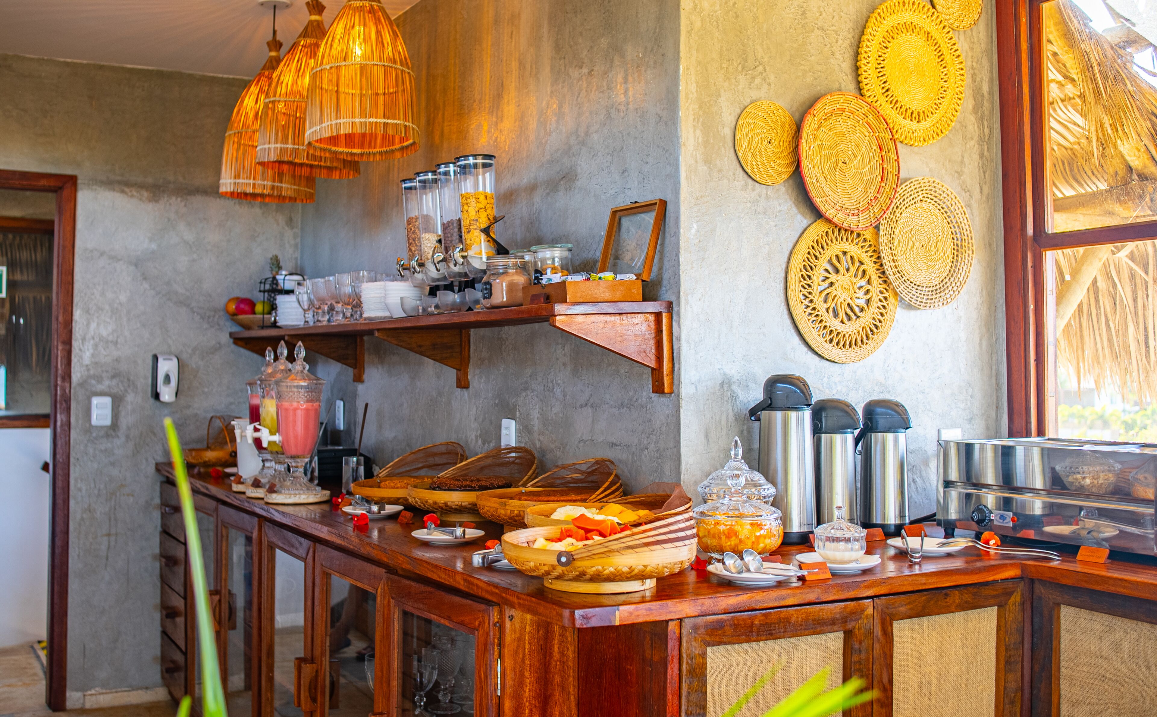 Un comptoir pour le petit-déjeuner avec divers aliments, un espace dédié au café et des éléments décoratifs fixés au mur.