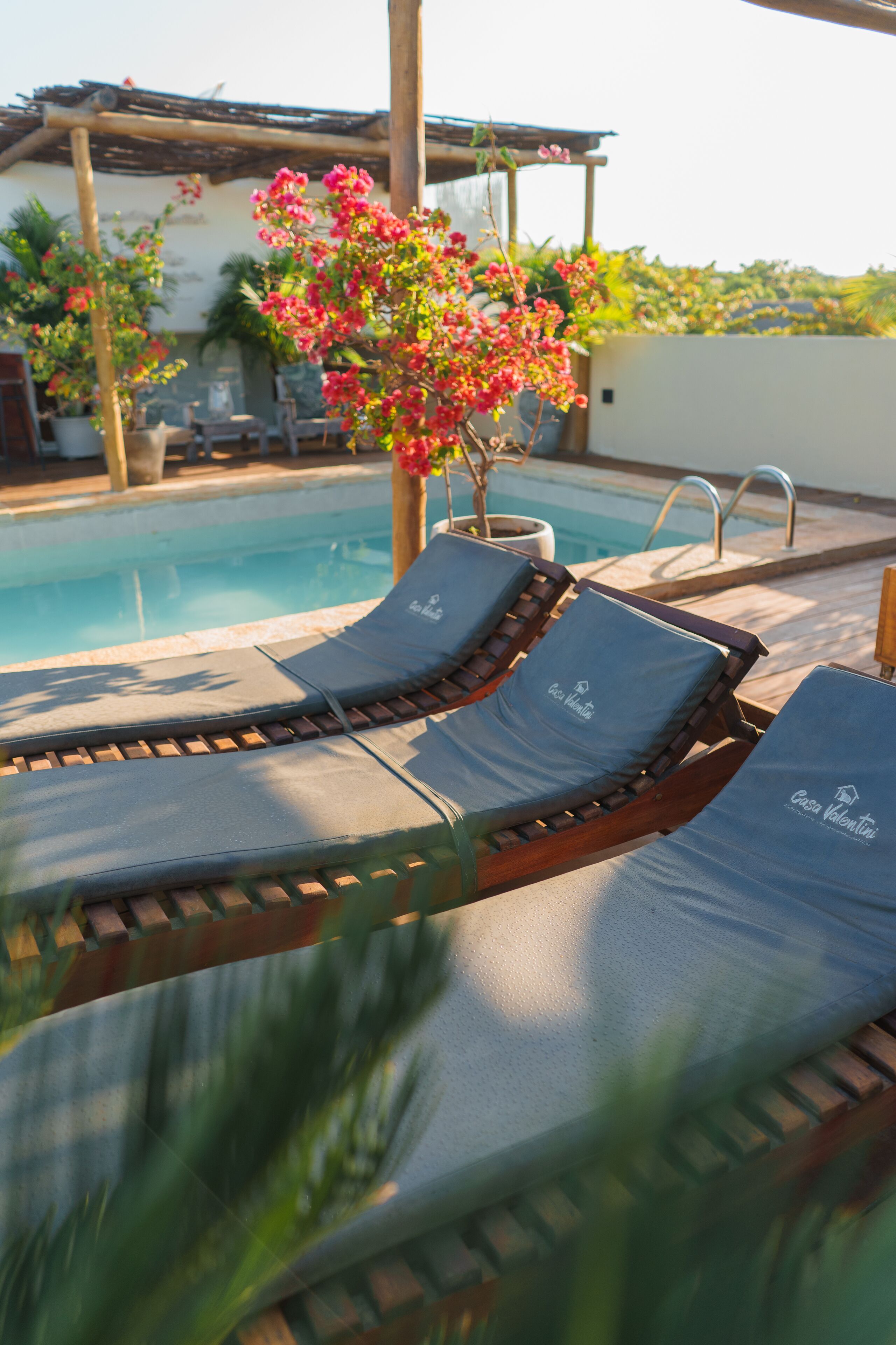 A poolside area with lounge chairs and a flower arrangement.