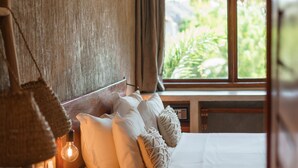 A bedroom with a bed, a small table, a lamp, and a window with curtains. - Casa Valentini Pousada (Jijoca de Jericoacoara)
