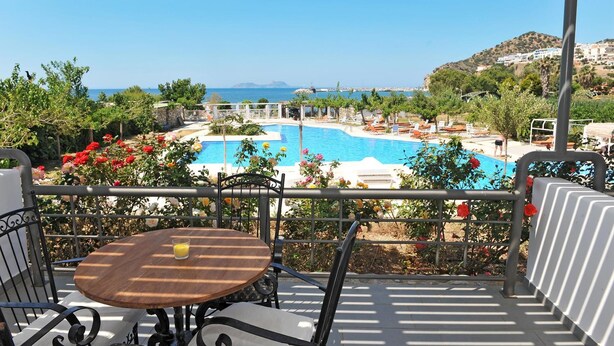 Eine Terrasse mit Blick auf einen Swimmingpool und das Meer.