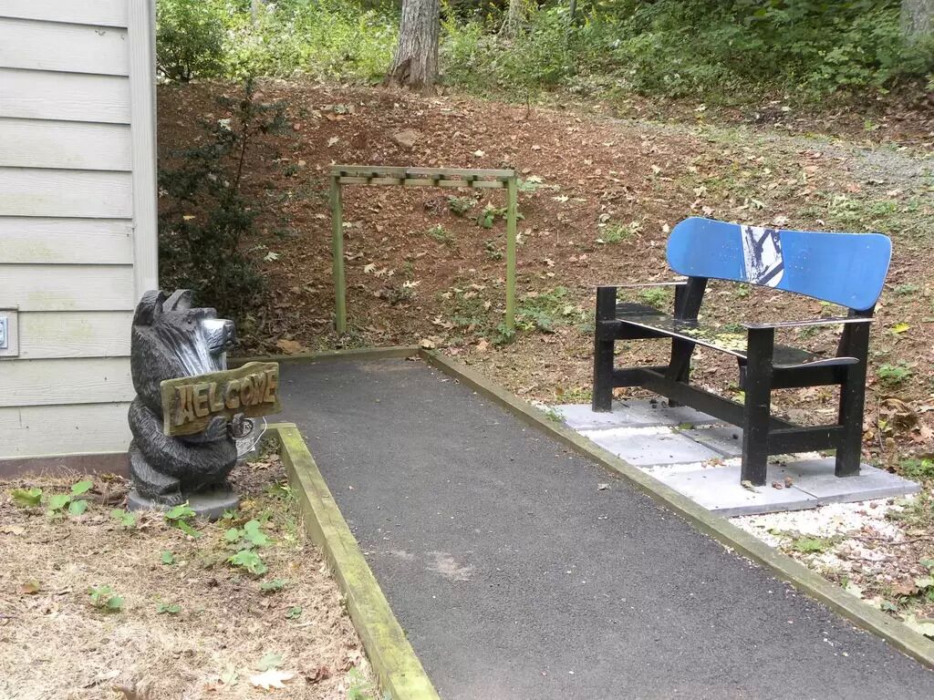 Eine Bank und ein Willkommensschild in einer Parkanlage.