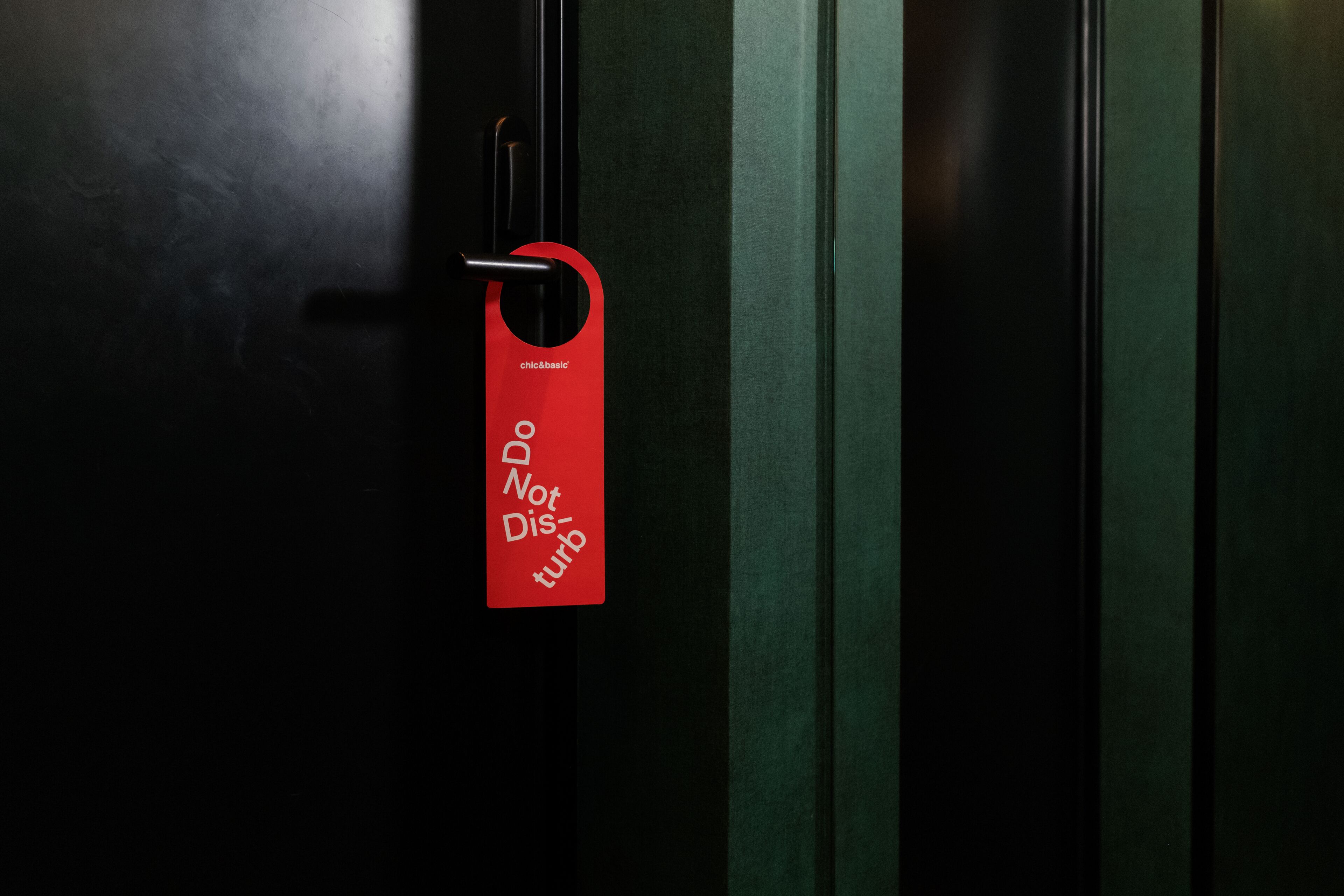 A door with a red tag that reads "chic&basic Not Disrupt".