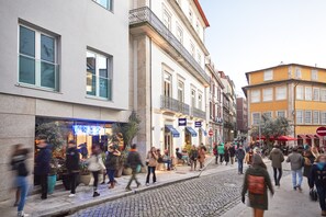 A bustling urban street with pedestrians, cafes, and historic buildings.