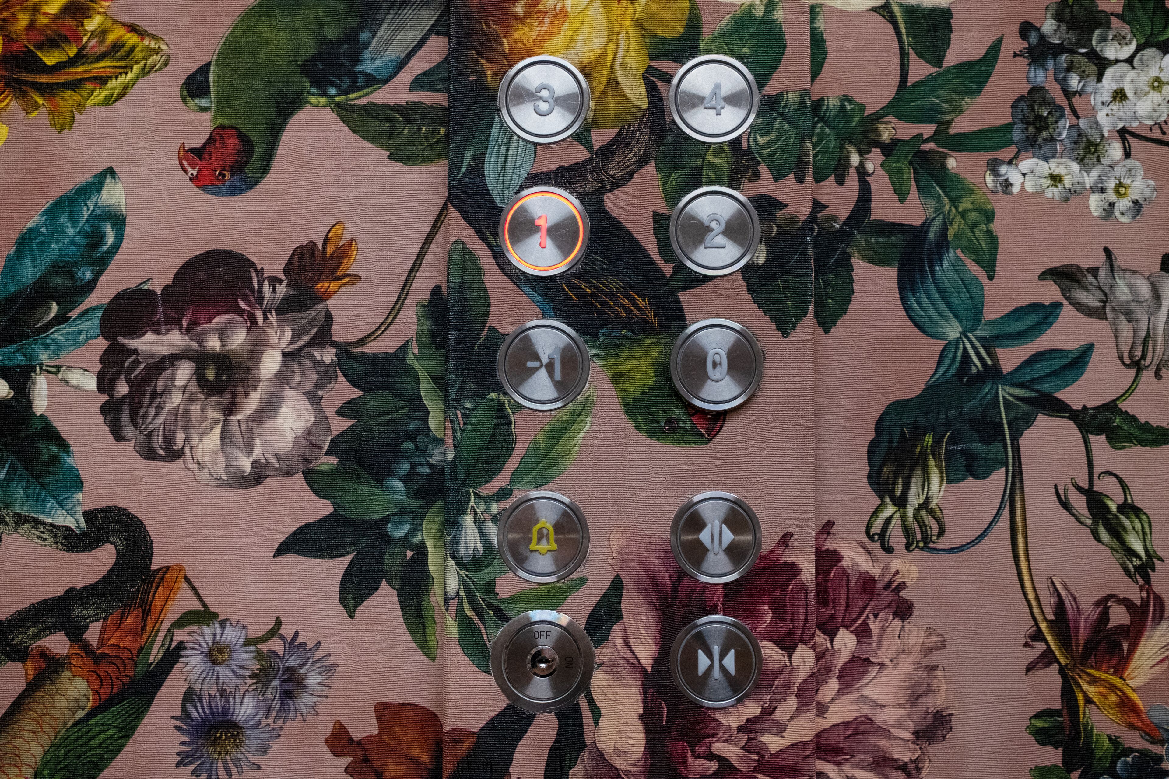 Un panneau de commande doté de boutons numérotés de 0 à 4 et d’un interrupteur « OFF », le tout placé sur un fond en tissu à motifs floraux.