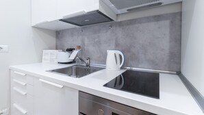 A modern kitchen with a built-in stove, sink, and a kettle on the countertop. - Italianway - Garibaldi 104 A (Milan)