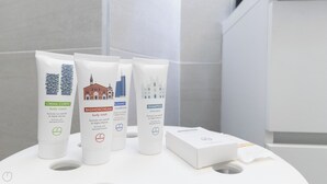 A bathroom with toiletries including body wash, shampoo, and body cream. - Italianway - Garibaldi 104 A (Milan)