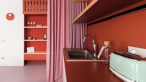 A modern kitchen with a sink, a kettle, and a toaster. There is a wooden shelf with glasses and a kettle. - Italianway - Bassini 31 (Milan)