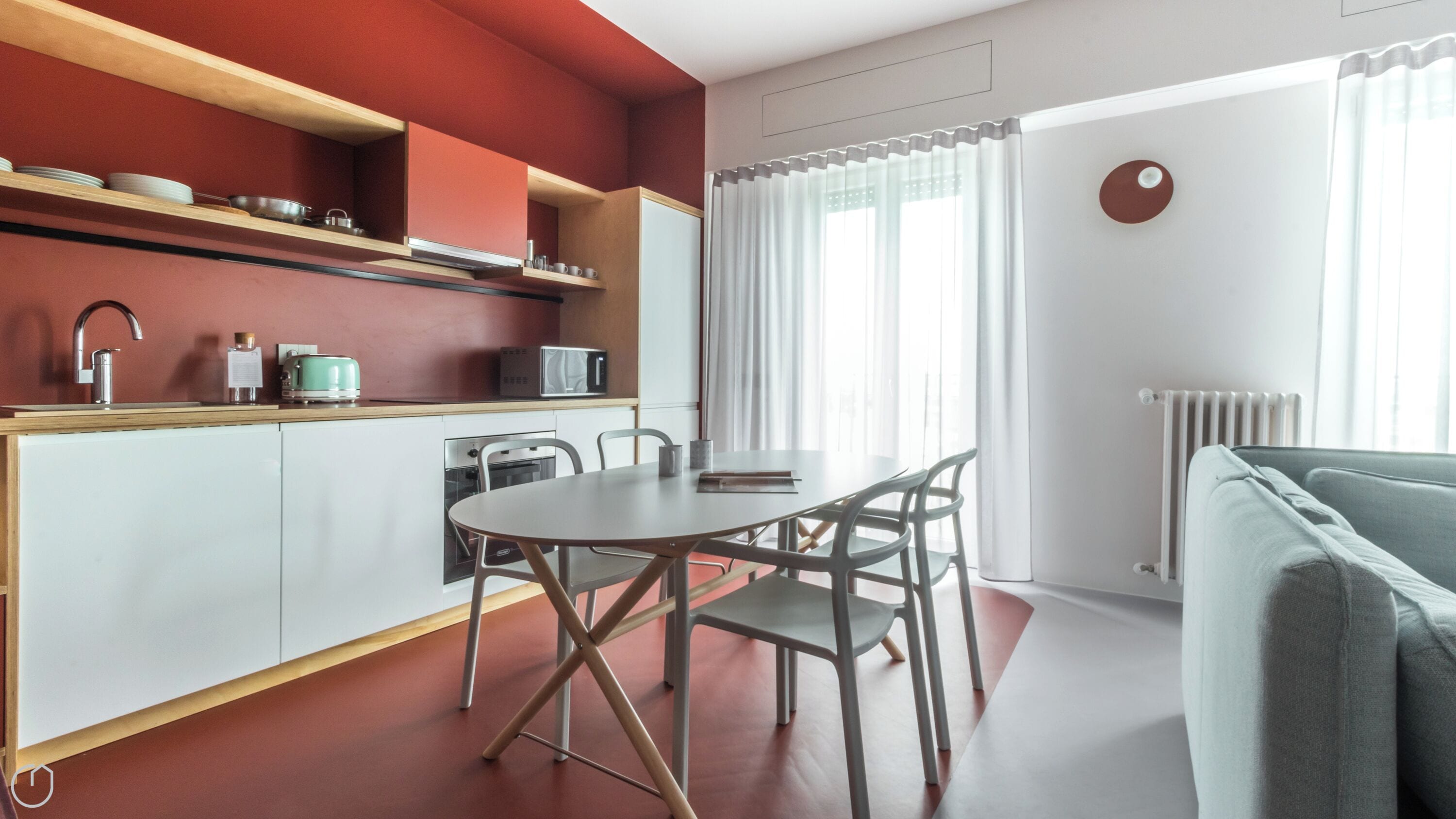 A modern kitchen with white cabinets, a wooden countertop, and a dining area with a round table and chairs.
