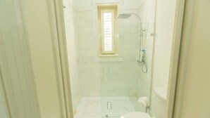 A small, tiled bathroom with a shower, toilet, and a window. - Luxury Golf View Villa in Punta Cana Resort & Club with Private Pool and Jacuzzi (Punta Cana)