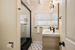 Ein Badezimmer mit Dusche, Waschbecken und Toilette.