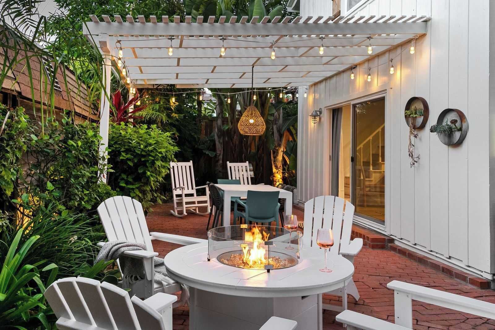 A patio with a round table, chairs, and a fire feature.