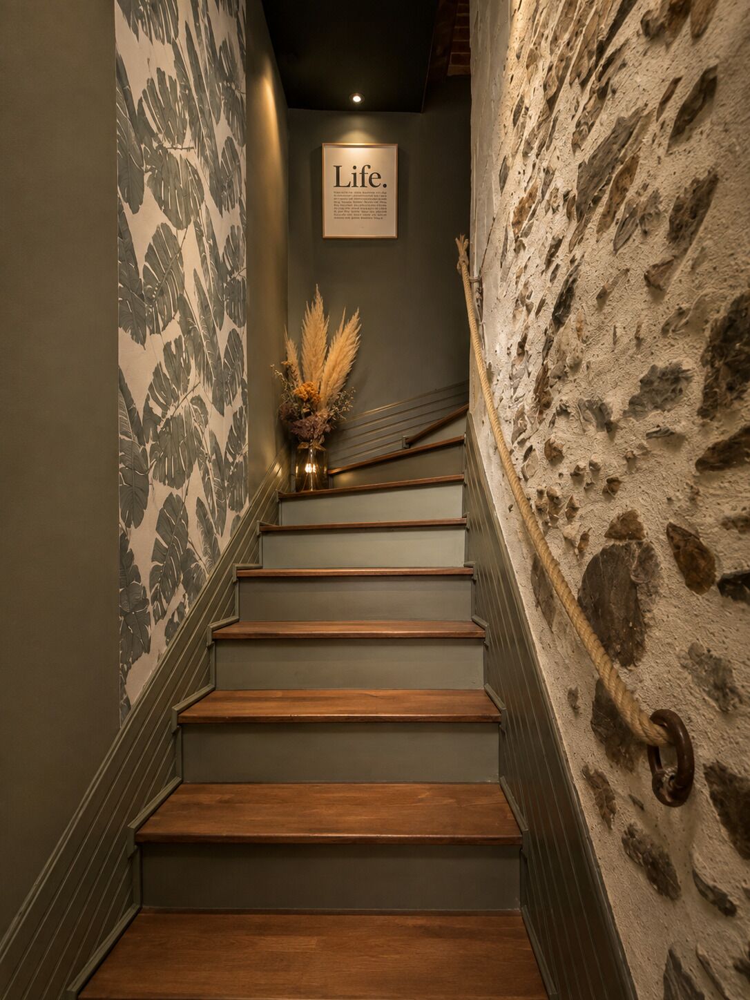 Una escalera con peldaños de madera y una pared con superficie texturizada.