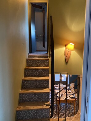 A staircase with patterned tiles leading to a dining area with a table set for two. - View over the Loire. Le Futreau, gîte 8/9 pers (Chalonnes-sur-Loire)