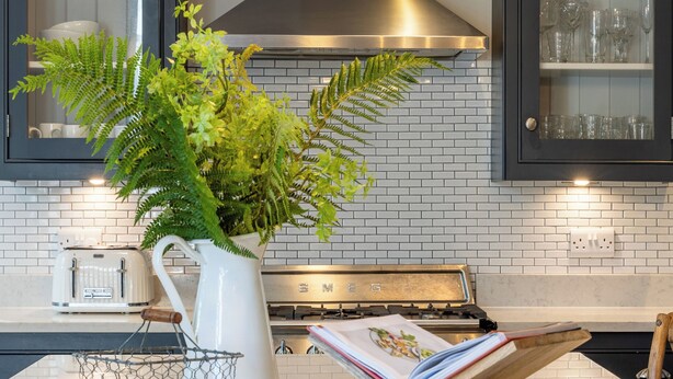 A kitchen with a white countertop, a stainless steel range hood, and a double hanging light fixture. - Timoleague West Cork Priory House  (Cork)