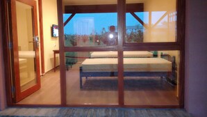 A bedroom with a large sliding glass door leading to a balcony. - Salas Farma 47 (Novi Sad)