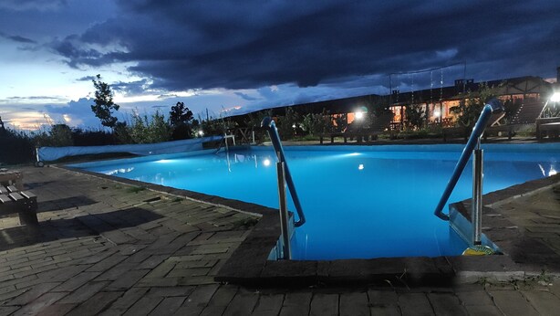 A swimming pool with metal railings, surrounded by a brick patio. - Salas Farma 47 (Novi Sad)