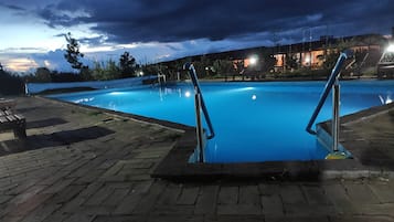 En säsongsöppen utomhuspool, parasoller och solstolar
