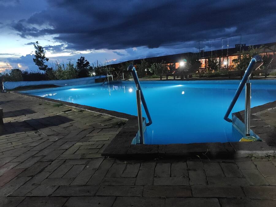 Una piscina al aire libre de temporada, sombrillas, tumbonas