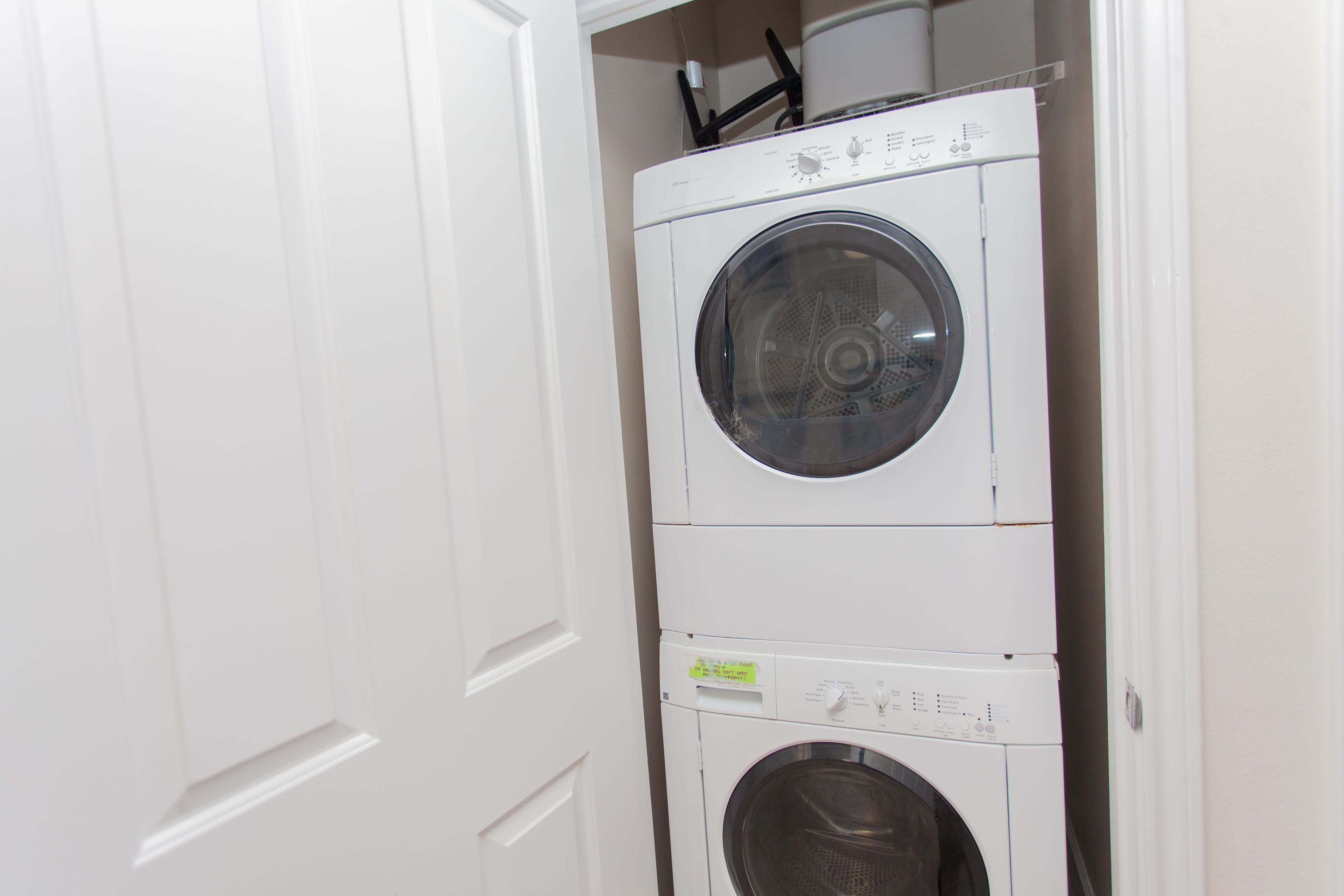 A stacked washer and dryer unit in a laundry room.