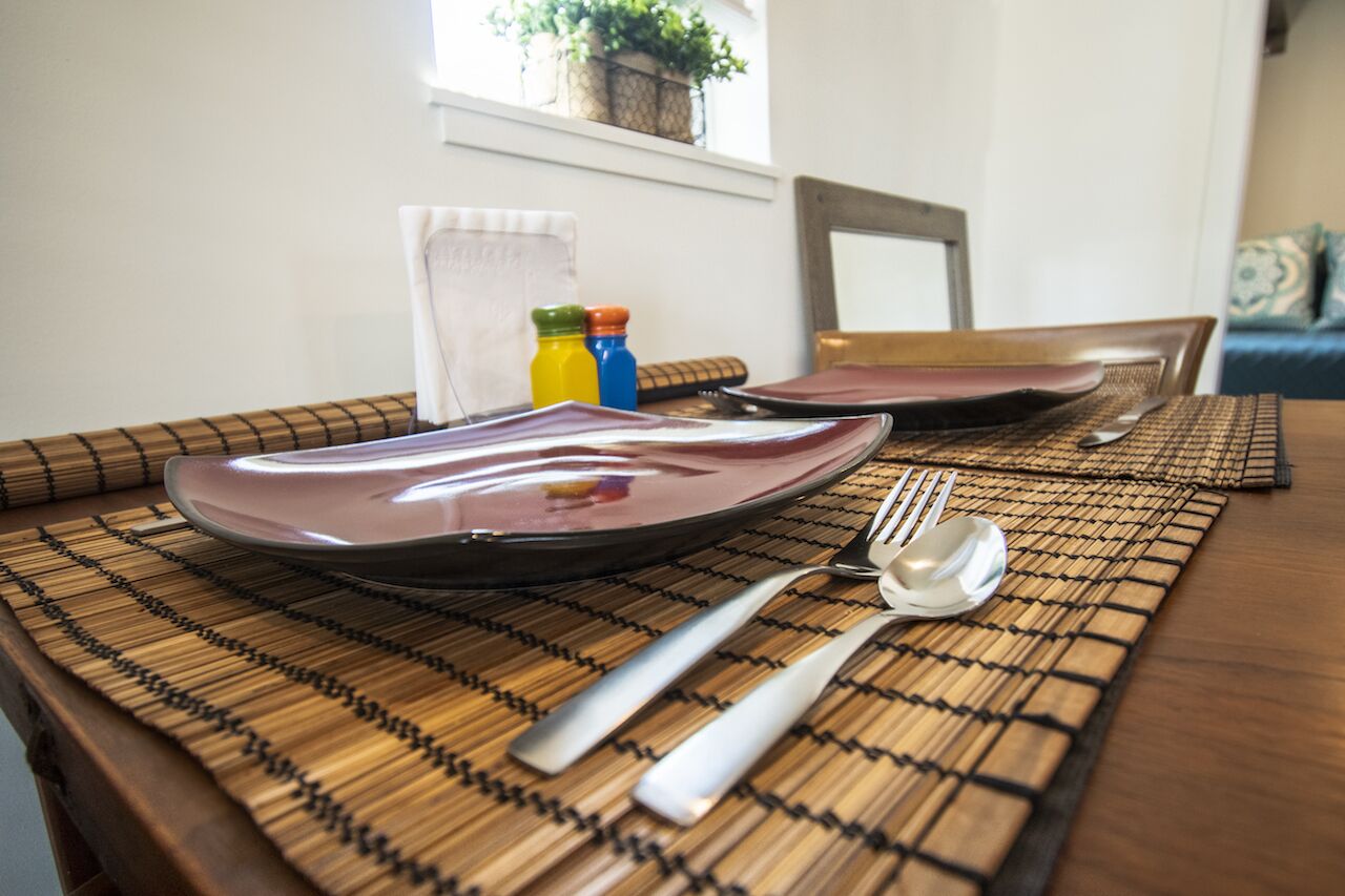A dining table set with plates, cutlery, and condiments.