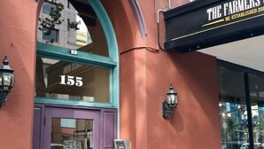 Un edificio con una puerta morada y el número 155.