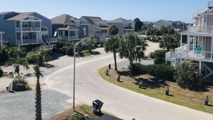 Zona residencial costera con casas de varios pisos, balcones y una carretera curva.