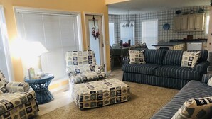 Una sala de estar con sofás a rayas, un sillón estampado y una pequeña mesa redonda.