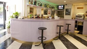 A bar area with a counter, stools, and a television screen. - Arha Santander (Santander)