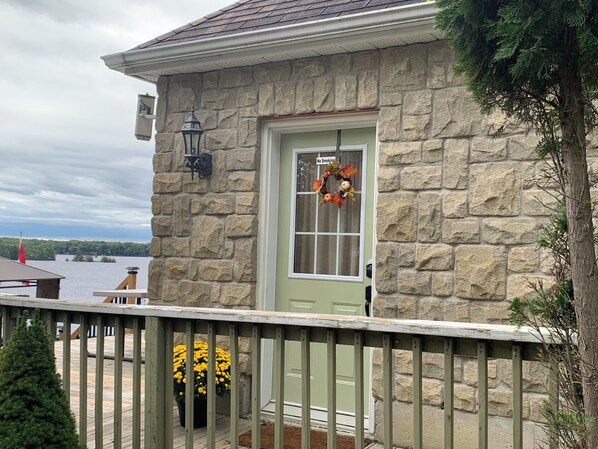 A stone building with a green door, a 'No Smoking' sign, and a wreath.