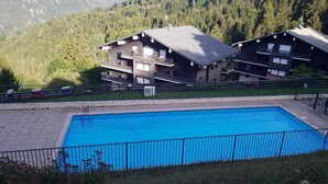 A modern building with a pool and a fenced area.