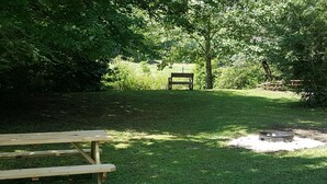 A picnic area with a bench and a fire pit.