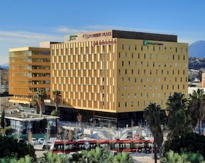 A multi-story hotel with a prominent 'Holiday Inn Express' sign, featuring a modern facade with a grid-like pattern of windows.
