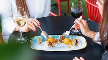 Una mesa de comedor con un plato de comida y dos copas de vino.