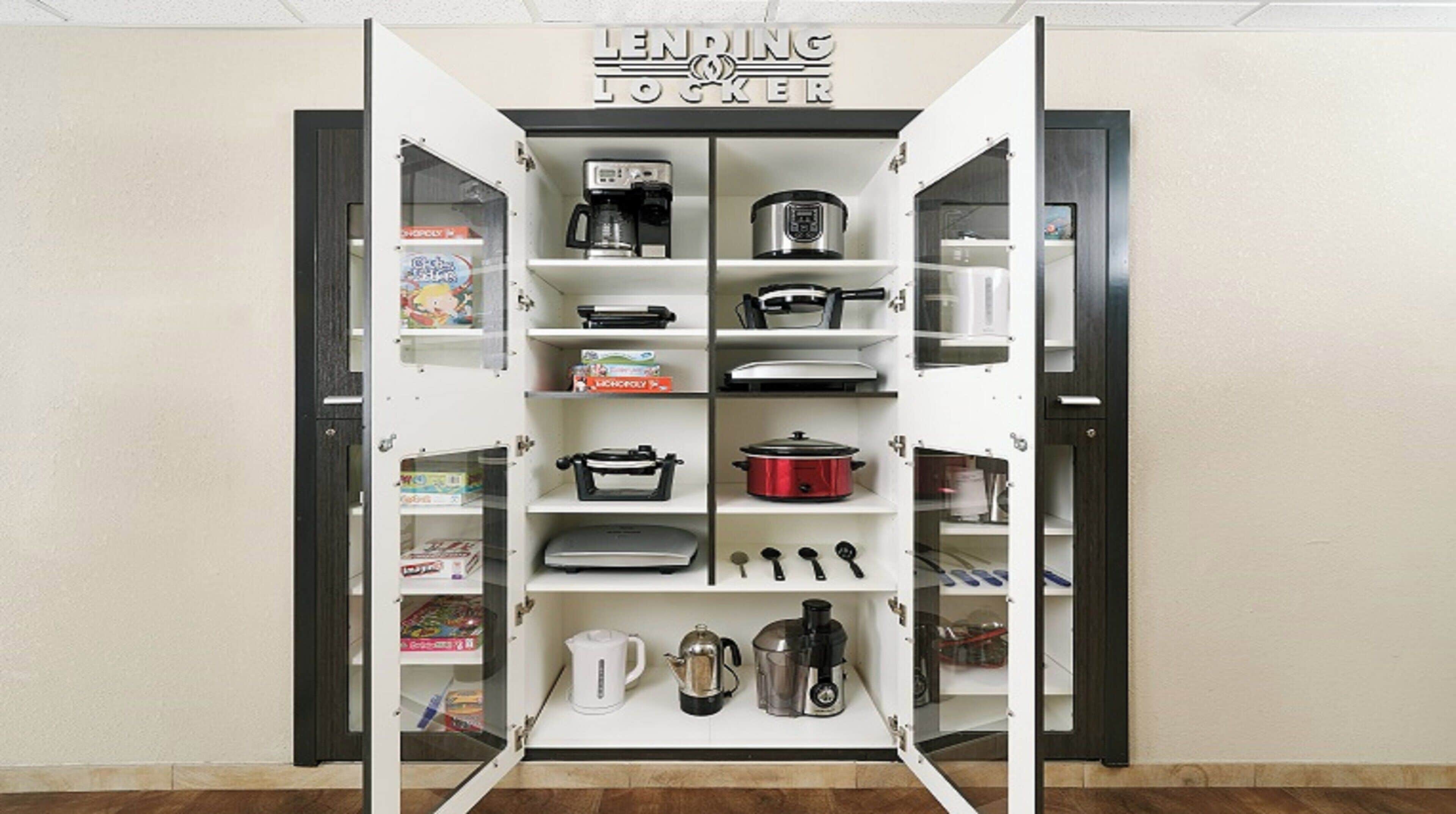 A kitchen with open cabinets displaying various appliances and cookware.