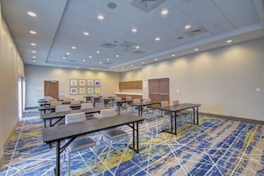 A conference room with multiple tables and chairs, a patterned carpet, and a ceiling with recessed lighting. - Holiday Inn Express & Suites Charlotte Southwest by IHG (Charlotte)