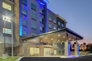 A multi-story hotel with a covered entrance and stone pillars. - Holiday Inn Express & Suites Charlotte Southwest by IHG (Charlotte)