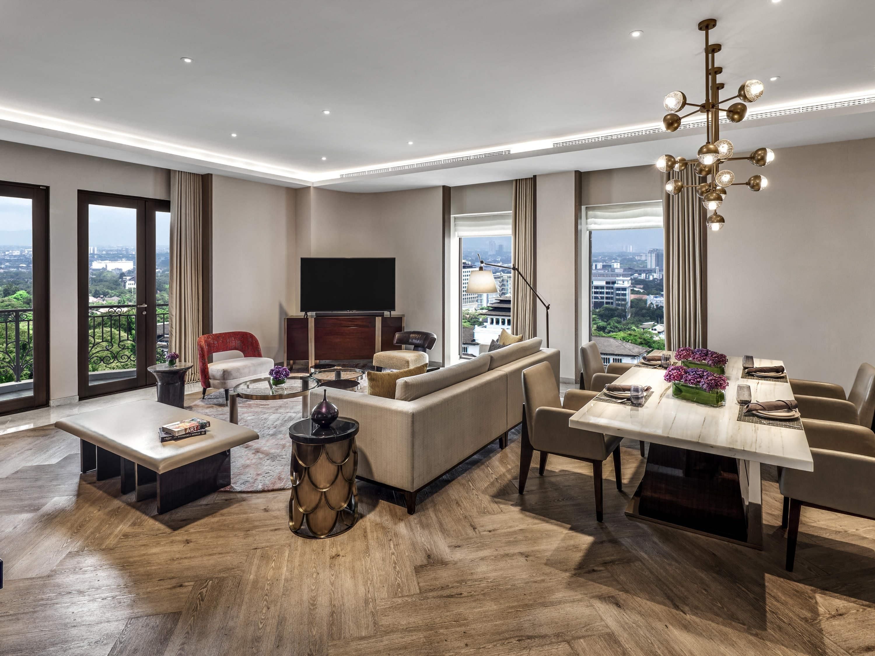 A spacious living room with a large sofa, a dining table, and a TV.
