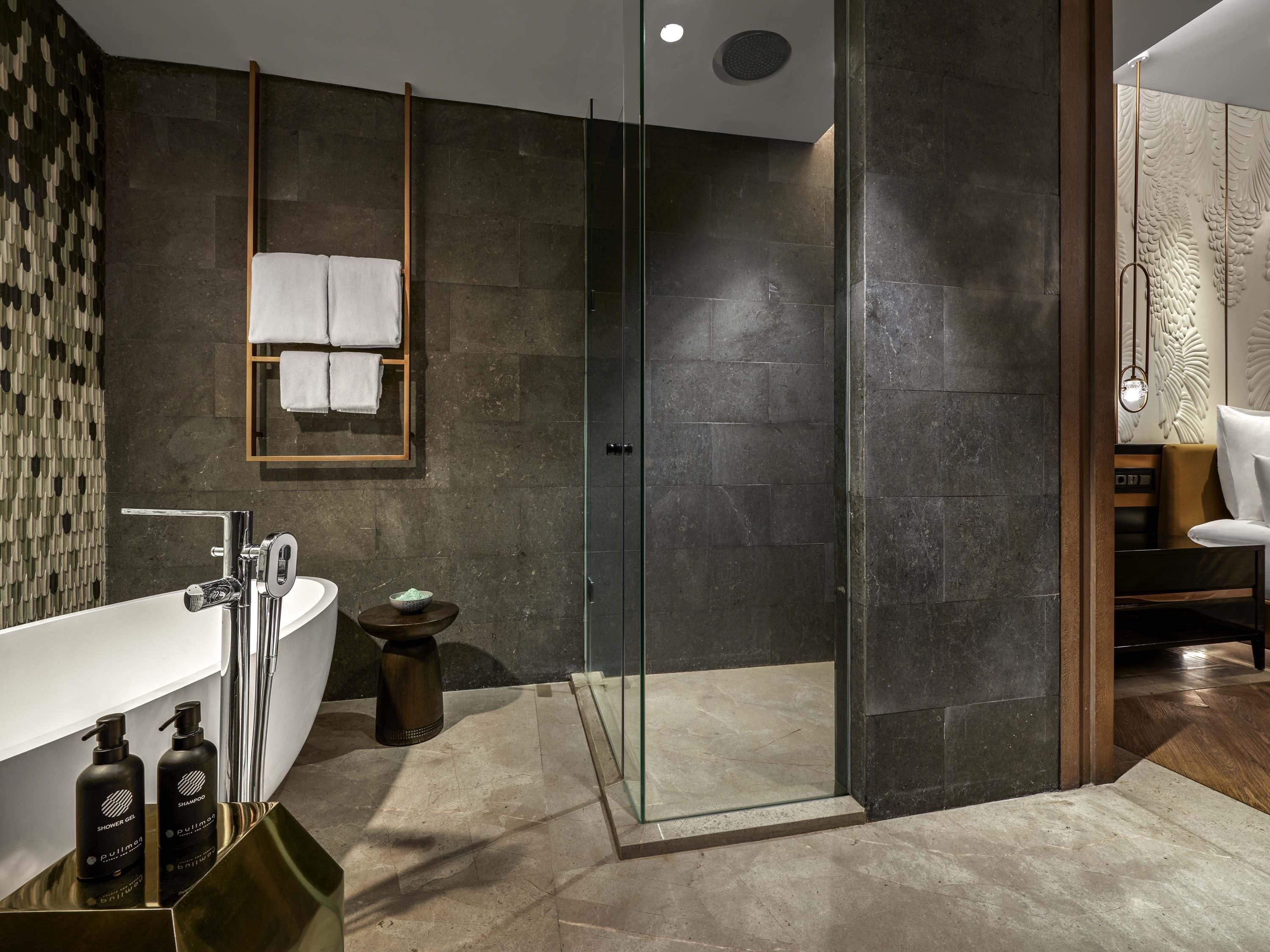 A modern bathroom with a glass-enclosed shower, a white sink, and a wooden vanity.