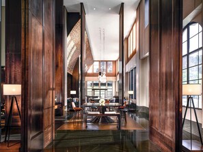 A spacious lobby with high ceilings, a central seating area, and large windows allowing natural light.