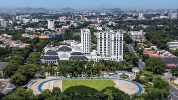 Un vaste complexe immobilier comprenant plusieurs immeubles de grande hauteur, entouré de verdure et d’un terrain de sport.