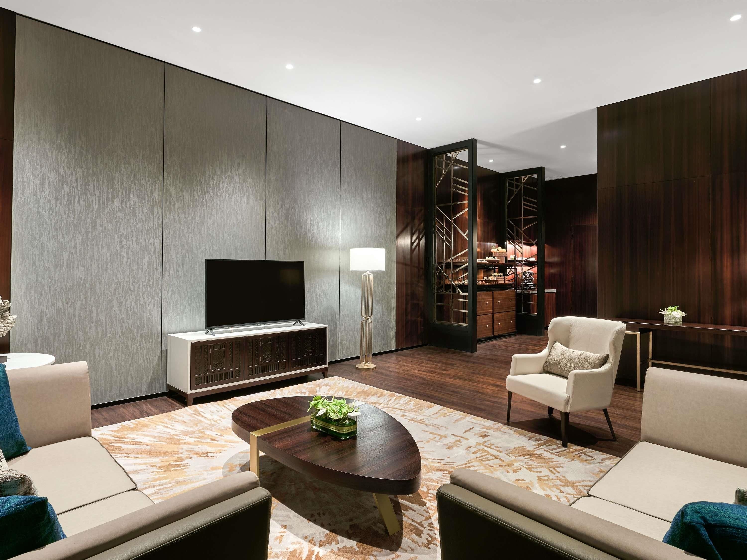 Ein modernes Wohnzimmer mit einem Flachbildfernseher, einem Couchtisch und Sitzgelegenheiten.