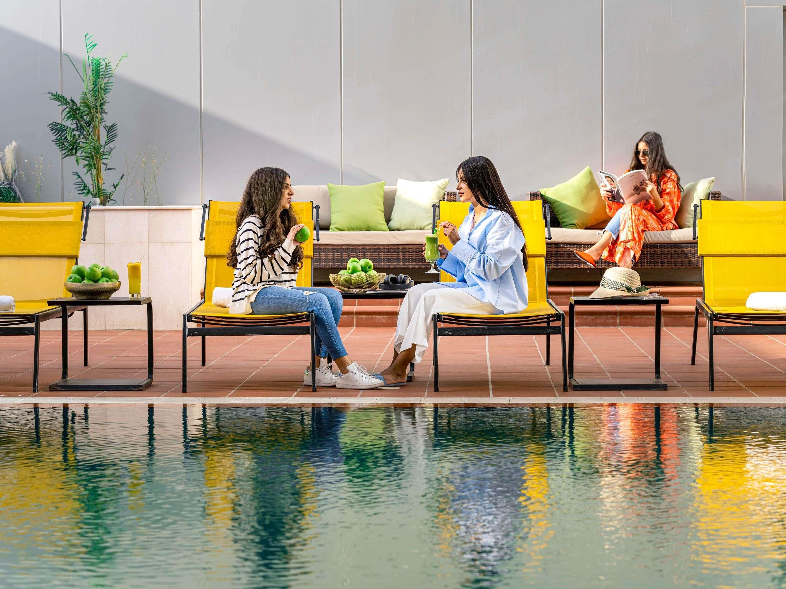Un espace aménagé au bord de la piscine, avec des sièges et un élément décoratif aquatique.