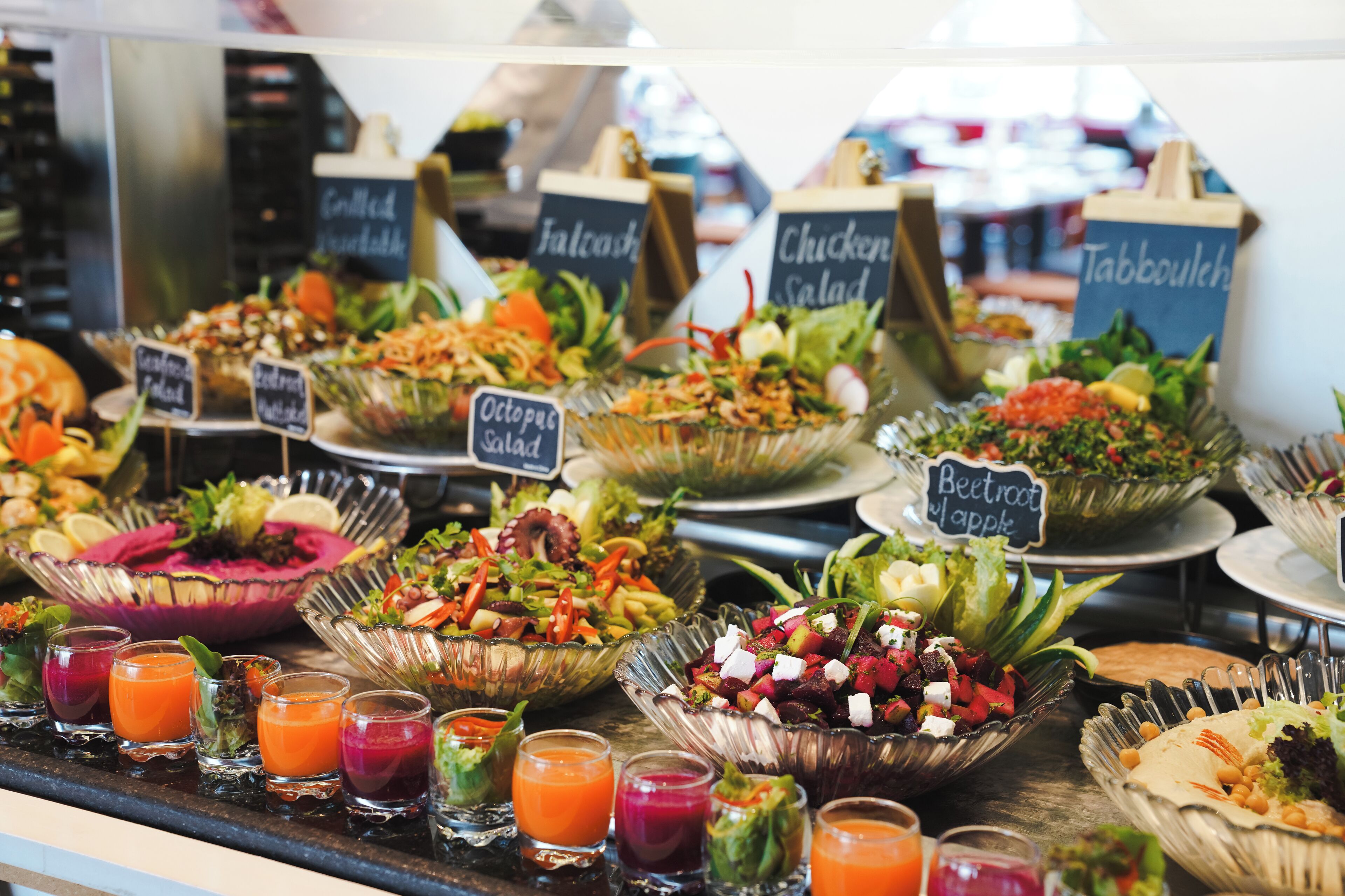 A buffet with various salads and drinks.