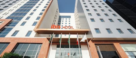 Un moderno edificio de hotel con un llamativo letrero que dice "ibis HOTEL".