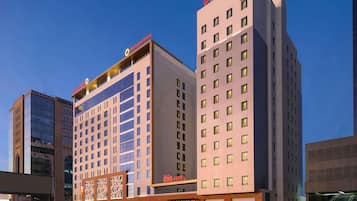 A hotel with multiple floors, a prominent sign for 'ibis hotel', and a modern architectural design.