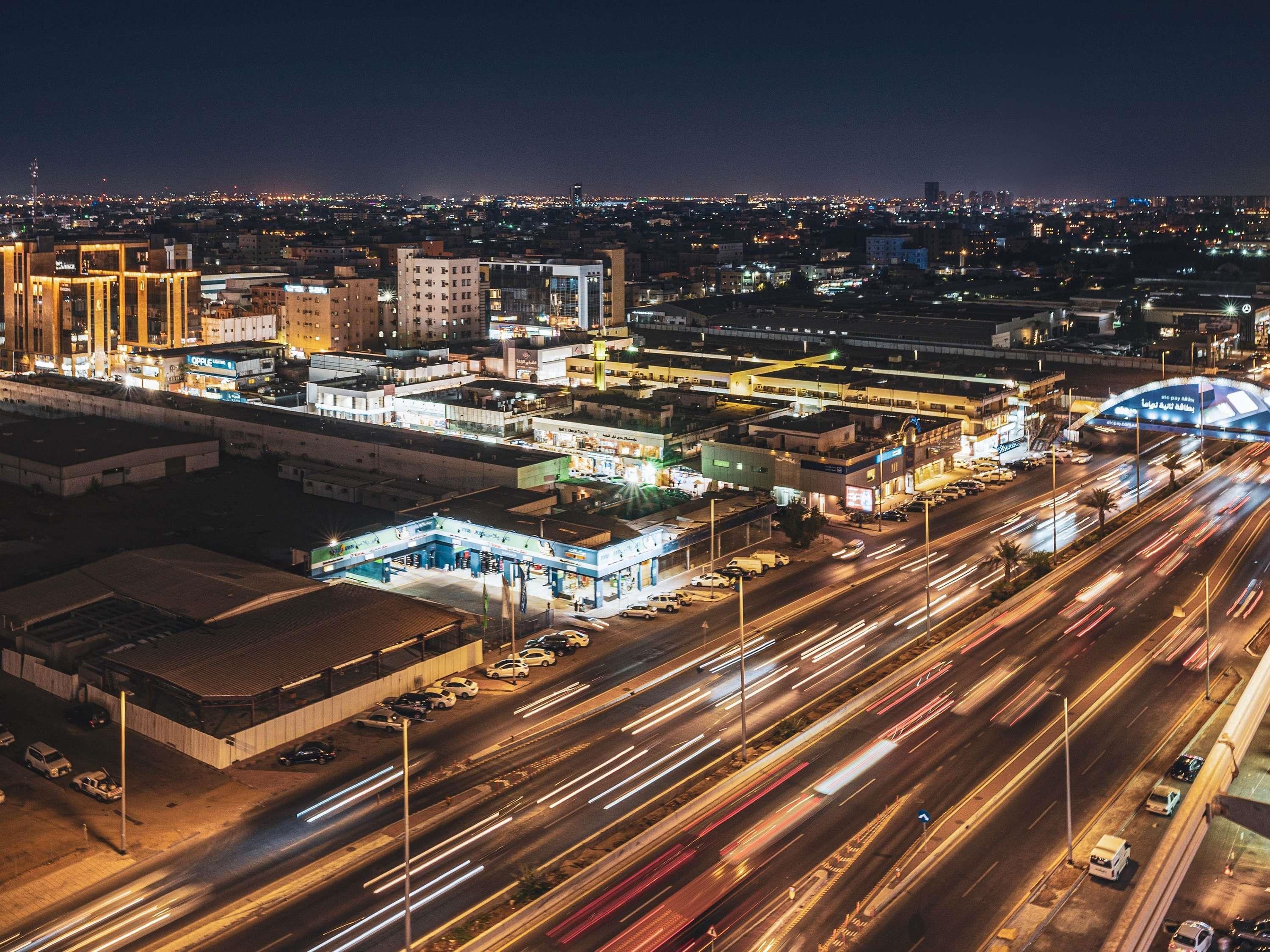 A nighttime cityscape with a highway and buildings.