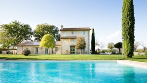Un bâtiment à deux étages avec une piscine devant.